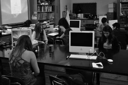 Juniors  Sophie Newman, Erica Hill, Aby Dulle and Leah Staenberg text during  Craig Sucherâ€™s biology class, taking advantage of the lab tables. (Tom Haslam)