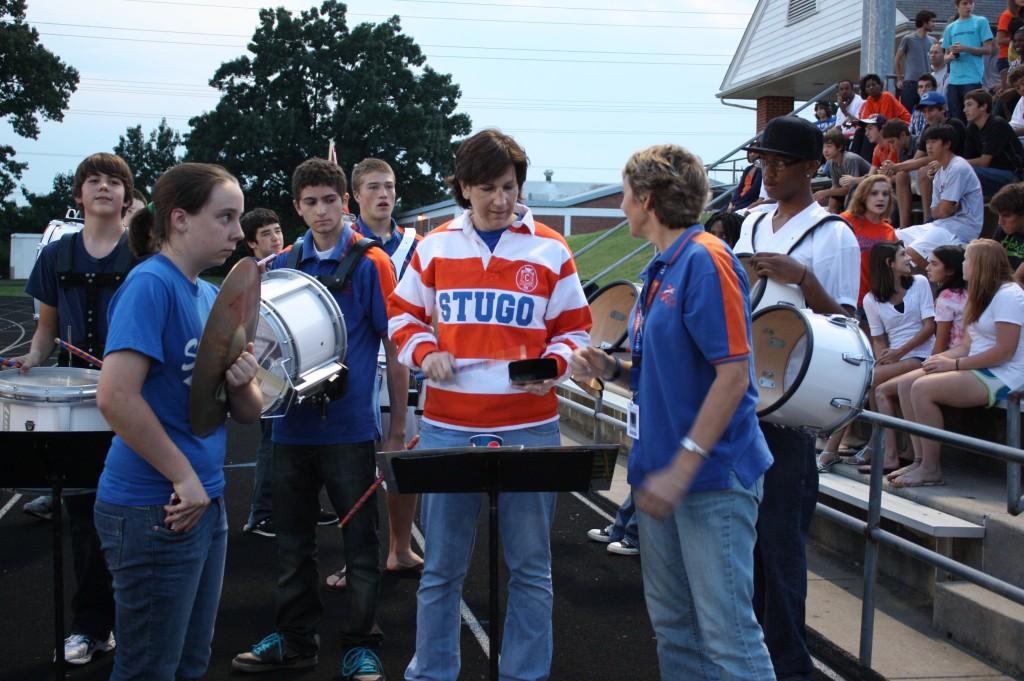 Principal Louise Losos plays percussion with the pep band at the opening football game. (Caroline Stamp)
