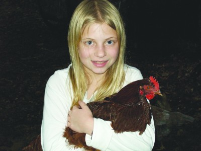 Chickens in Clayton Leah Peipert stands outside her Clayton home with Rhody, a Rhode Island Red chicken. The family spends about five to ten minutes each day caring for the chickens.