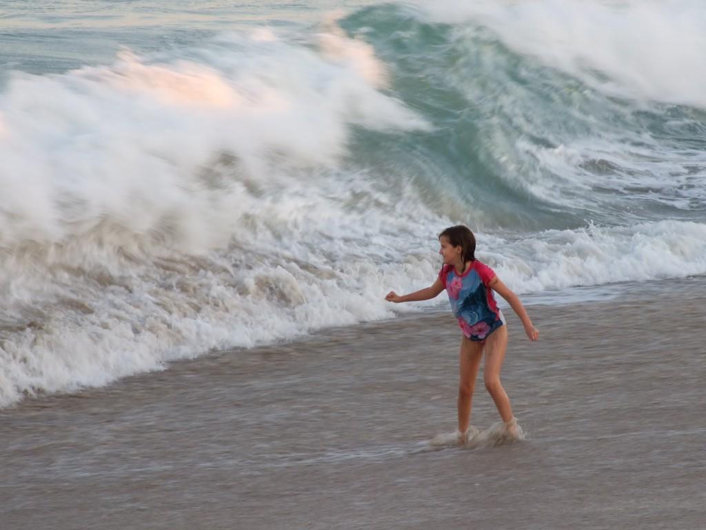 A girl prepares to be washed away by a huge and looming wave on one of the many beaches in Miami. (Willie Wysession)