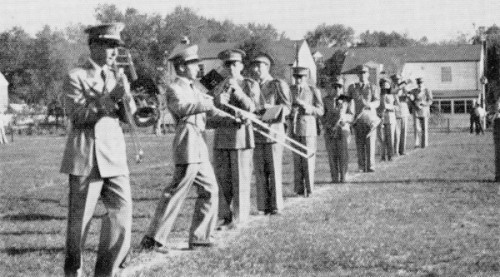 The 1954 CHS marching band performs for the crowd at a football game in full band attire.