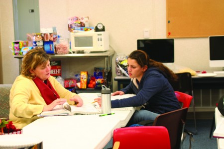 Teacher Jane Glenn assists freshmen Leslie Goodman with her math homework. Students have begun to use their teachers as resources outside of the class room for help instead of paying for costly tutors. To meet this demand the math department now staffs the math learning center.