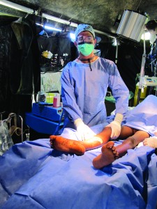 Perlyn operates on a patient in a hospital tent.