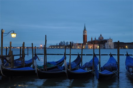The sun rises over the island of San Giorgio Maggiore and the gondolas of Venice, Italy.