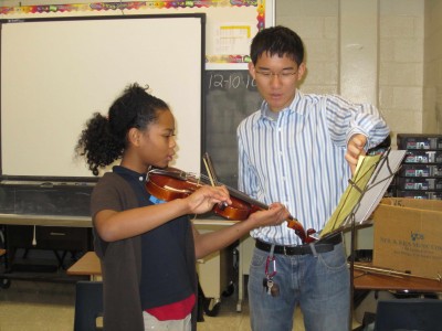 CHS graduate Ken Zheng works with with a violinist at Stevens Middle School as part of the program they founded, Making Music Matters.  The Organization, which had has been aided by the United Way, provides violin instruction to inner city students who do not have an orchestra program at their school.