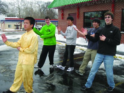 Sophomore Dan Zeng leads fellow Chinese students in tai chi lessons. (Hongling Zhang)