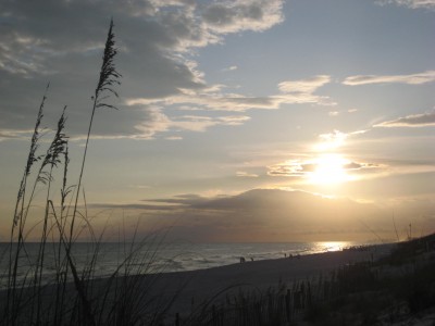 The sun sets over the white sandy beach of Destin Florida.
