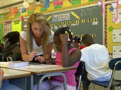 An Education Exchange Corps Volunteer works through a problem with one of the students. (Courtesy of Elad Gross)