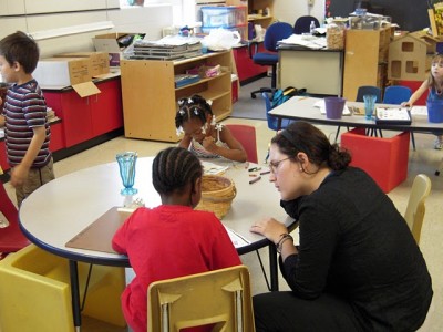 Elementary school students receive instruction on their work from a volunteer. (Courtesy of Elad Gross)