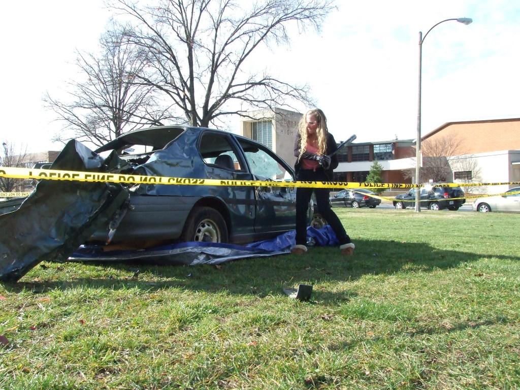 Senior Lauren Hill takes out her final's frustrations by swinging at a car for a fundraising event the Friday before exams.  To promote an anti-smoking campaign, DECA students teamed up with The Evolvement to hold a Car Smash.