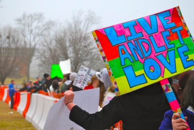 At the Westboro Baptist Church counter-protest outside of CHS last monday, an anonymous picketer holds up a sign reading, "Live and Let Love". Organized by the GSA, students from other schools, alumni, neighbors, friends, and many others came to peacefully and eloquently voice their support of equality, love, and hope: promoting a spirit of solidarity among the community. Photo by William Wysession