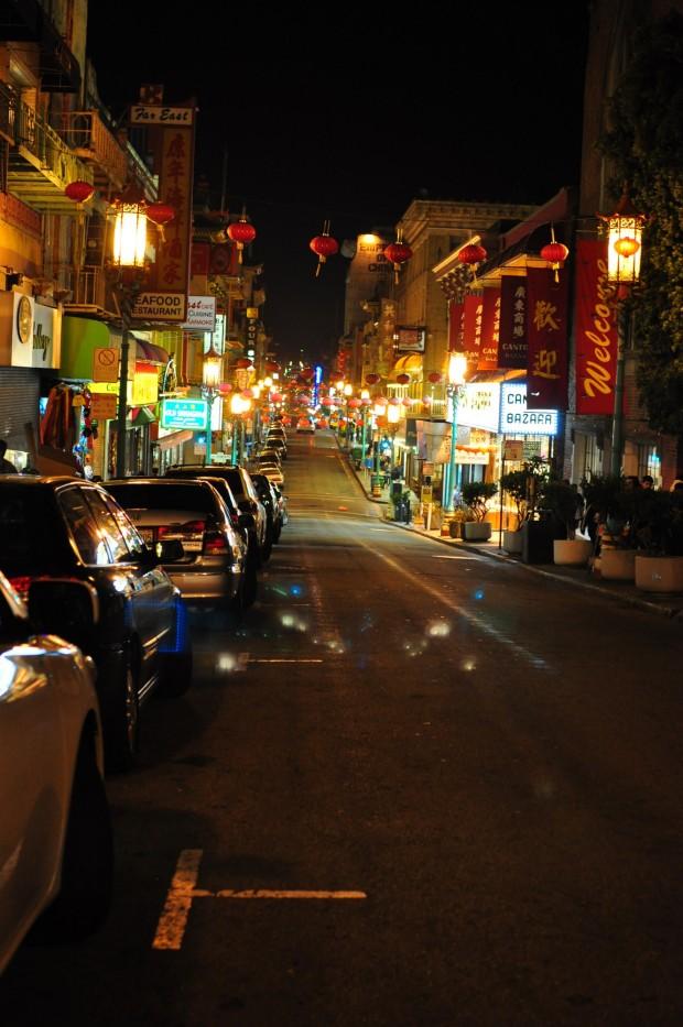 San Fransisco's Chinatown is brightly lit on a calm summer night. This Chinatown is comprised of a few blocks filled with restaurants, bakeries, and stores filled with trinkets. 