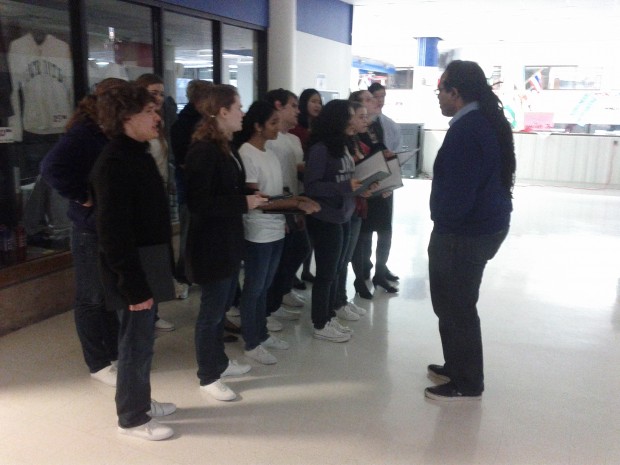 Coach Jonathan Smith leads the team in vocal exercises at the district competition. (Justin Seiwell) 