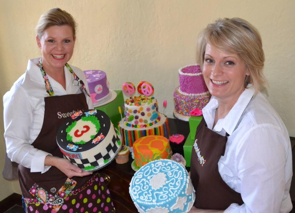 The two co-founders of Sweetology, Kara Newmark (left) and DeAnn Bingaman (right) stand with their decorated cakes. 