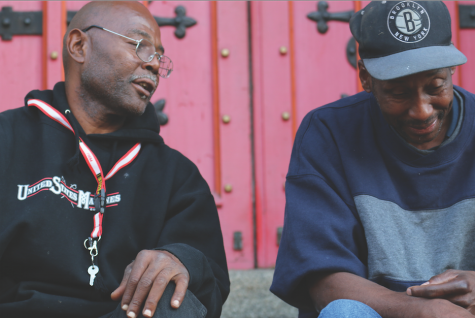 Two homeless men converse on the steps outside of a church is downtown St. Louis.