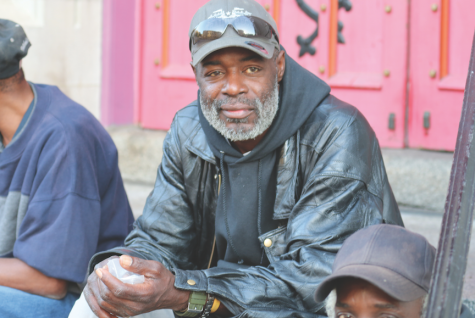 A homeless man sitting on the steps outside of a church in downtown St. Louis.