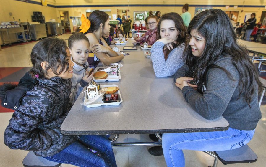 Anderson Elementary second graders Leslie Ayala-Munoz, left, and Ariana Allen, center left, have lunch with West High junior Destiny Reicher, center right, and Salma Nunez, far right, at Anderson during a nationwide event called No One Eats Alone Friday, Feb. 10, 2017 in Wichita, Kan. (Fernando Salazar/Wichita Eagle/TNS)
