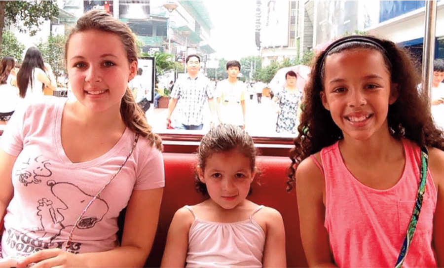 The Becker sisters riding through the streets of China. 