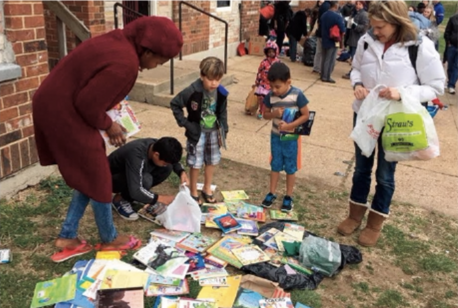 Refugee children look at books donated by Clayton students. Photo from Cyril Loum.