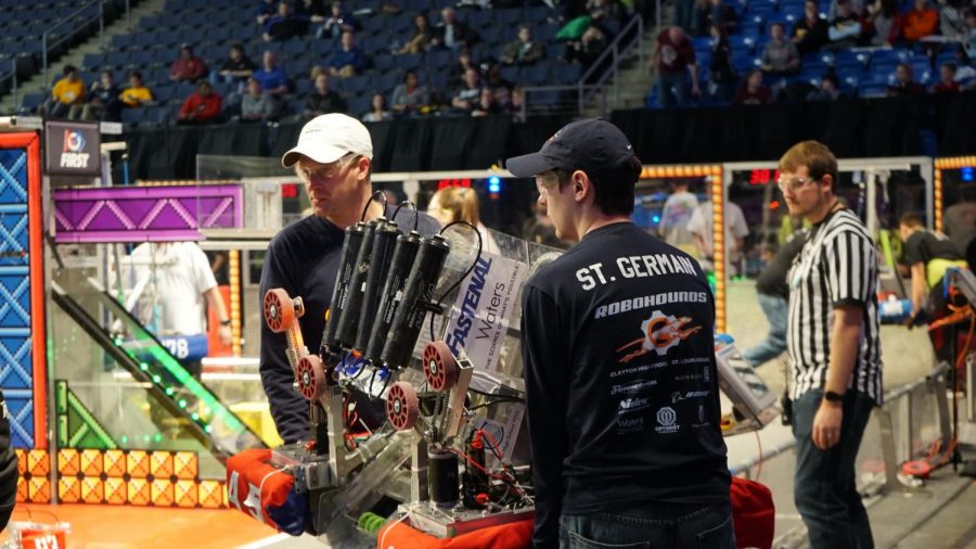 CHS engineering teacher Stephen Beauchamp (left) and Owen St. Germain, Class of 2018 (right) carry their teams robot off the field at a FIRST robotic competition in 2018.