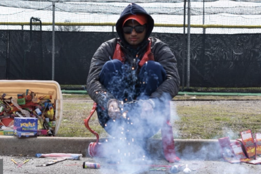 Photo of a man lighting fireworks.