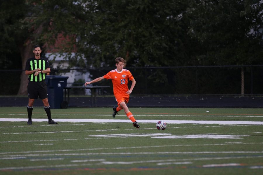 Senior Greg Pierson passes the ball to a teammate at a boys varsity soccer game.