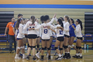 The volleyball team talking during a time out. 