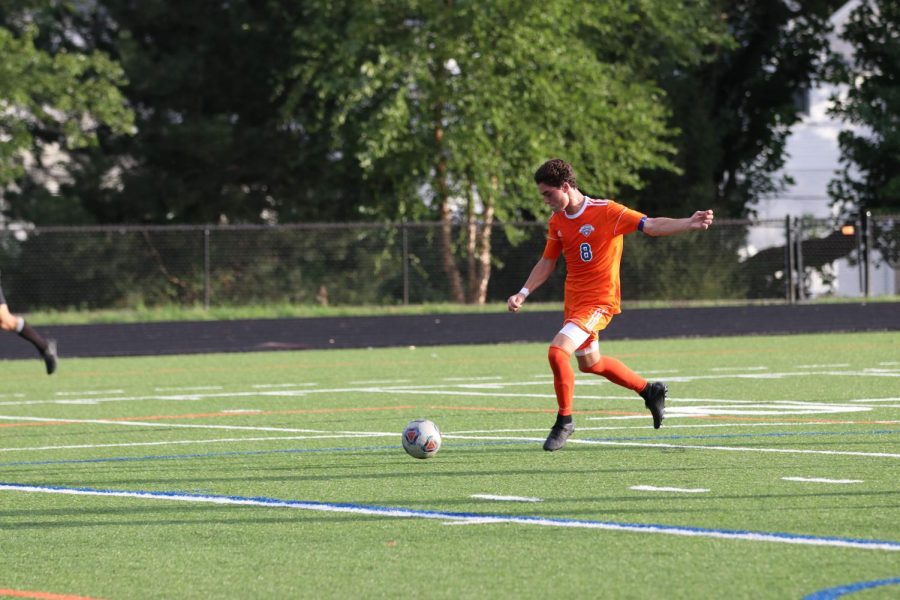 Senior James Dulle (8) moves to kicks the ball down the field in a game in early September. In the hounds game against rival school Ladue, Dulle scored both of the teams goals to defeat Ladue 2-1.