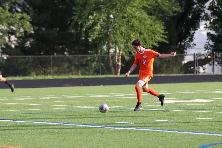 Senior James Dulle (8) moves to kicks the ball down the field in a game in early September. In the hounds' game against rival school Ladue, Dulle scored both of the teams' goals to defeat Ladue 2-1.