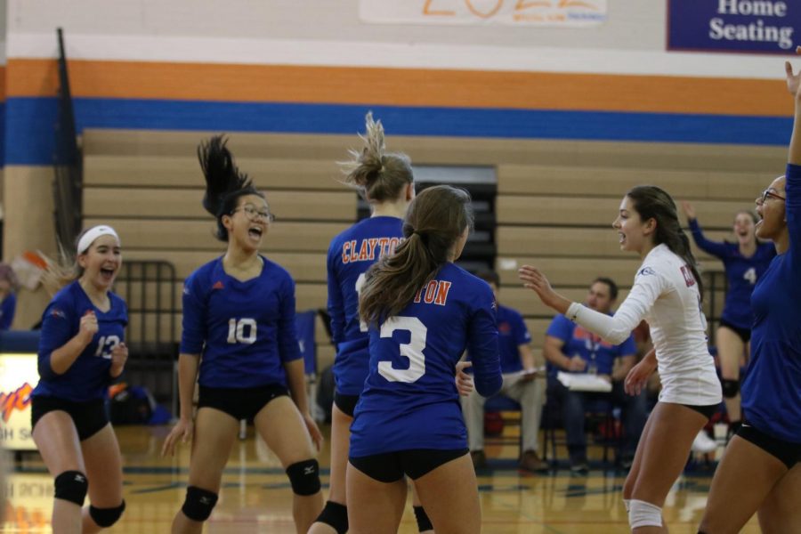 The+girls+varsity+volleyball+team+celebrates+after+scoring+a+point+in+their+game+on+Oct.+3.+