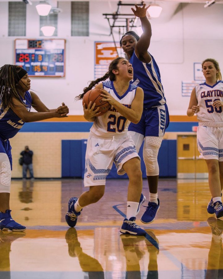 Junior Sara Litteken (20) dribbles toward the basket during the first girls' varsity game of 2018. 