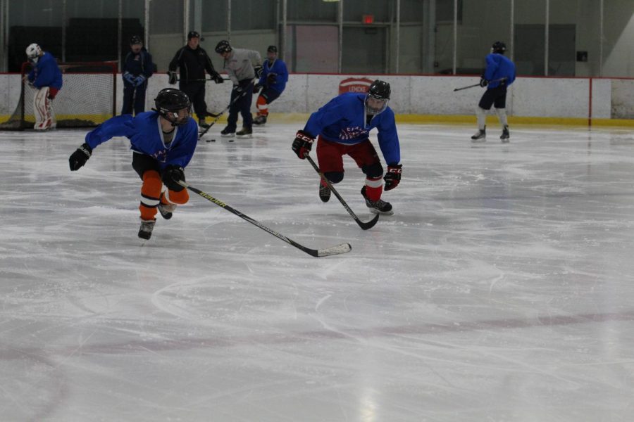 Two Clayton ice hockey players race against each other across the ice during one of the teams practices.