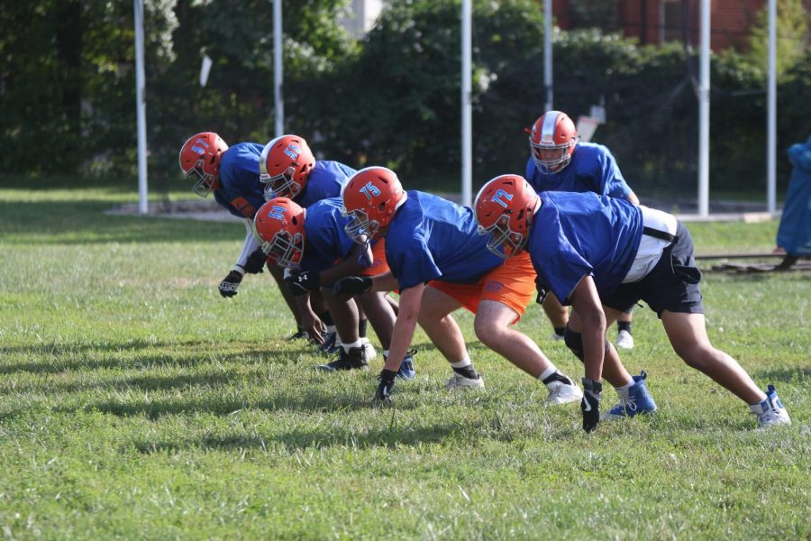 The Greyhounds work on a new play during a practice at Gay Field.