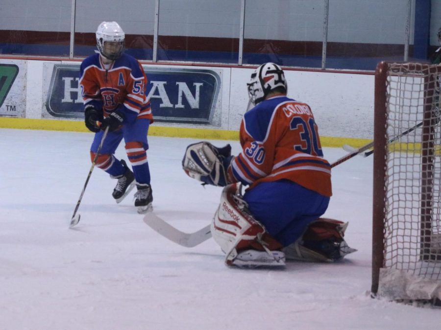 Varsity hockey players Daniel Cohen (left) and Mariano Colombo (right) move to block the puck during a game against MICDS on Jan. 12, 2019. 