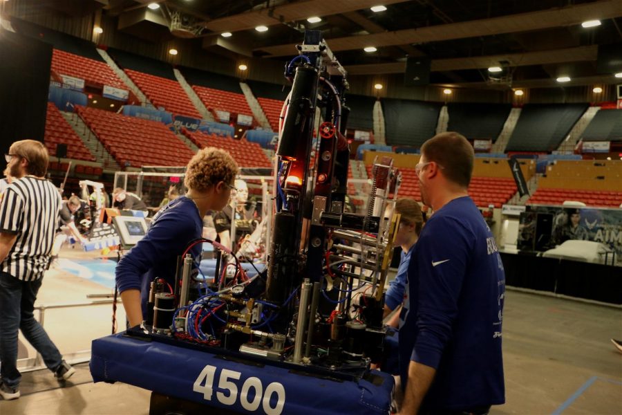 The Robohounds carry their bot towards the competition field before a match in Oklahoma City. From left to right: junior Max Walter-Morrissey, sophomore Olivia Zindel, engineering teacher Stephen Beauchamp.