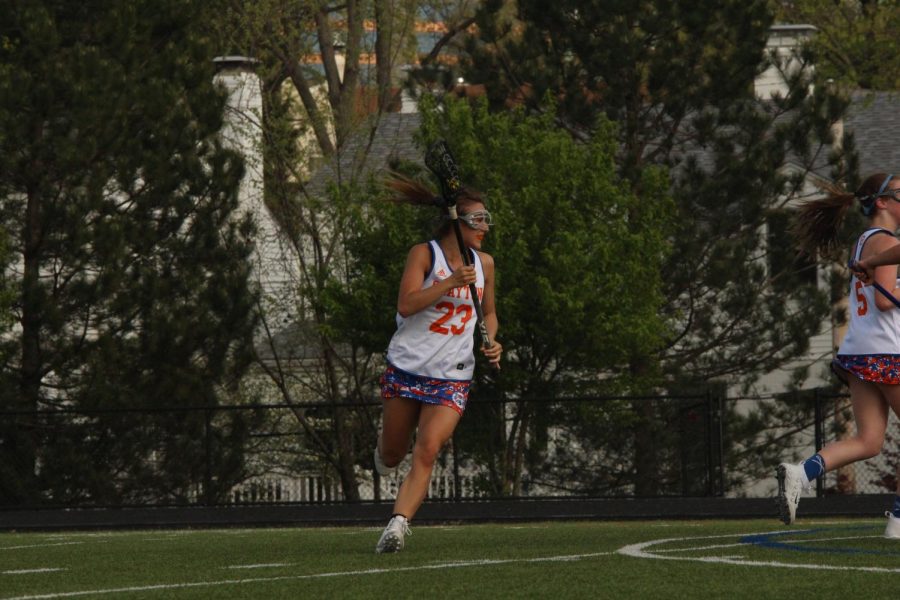 Caroline Marsden runs across the field during a lacrosse game.