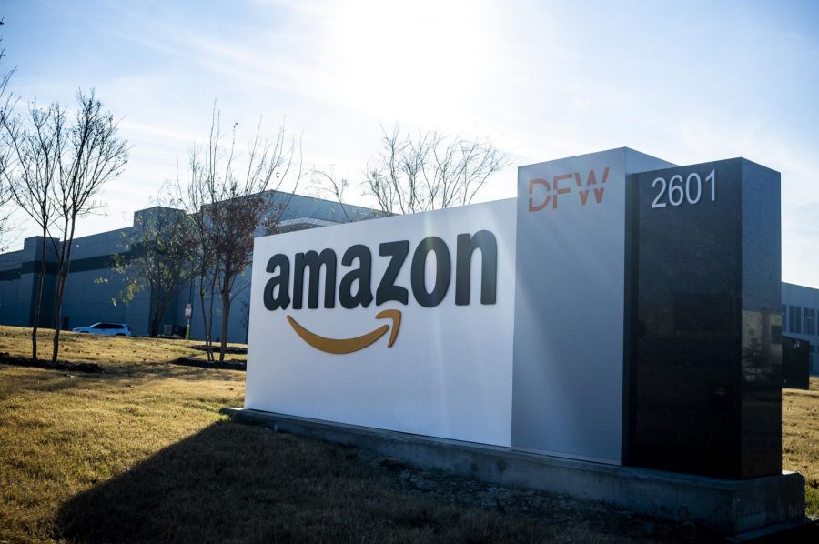 The prominent Amazon company logo is displayed on the entrance to a fulfillment center in Grapevine, Texas. 