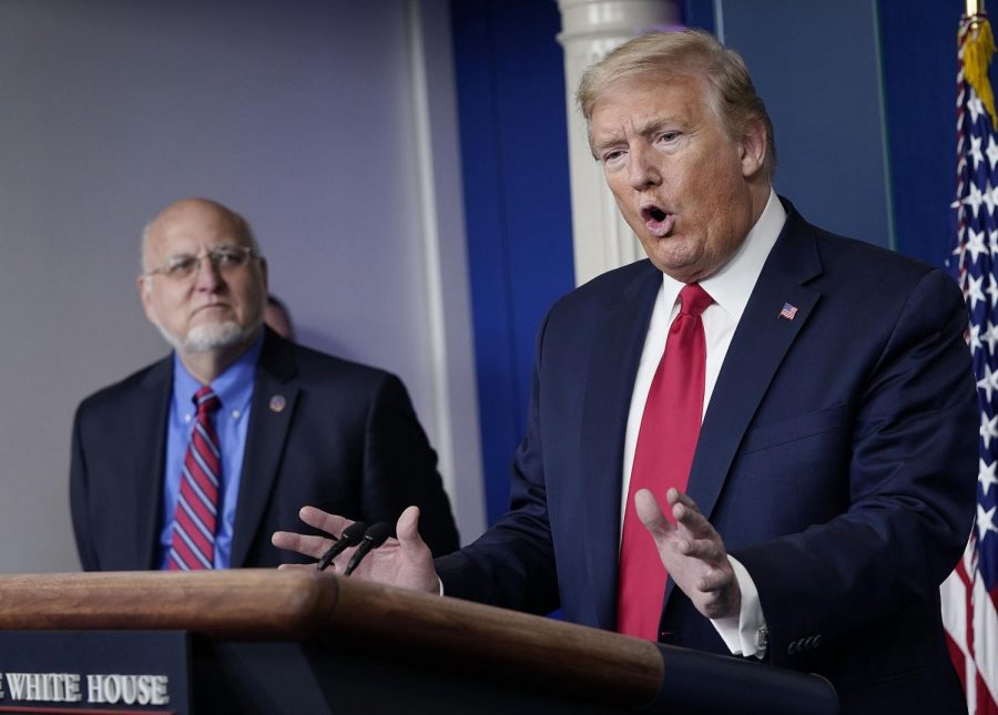 President Donald Trump, right, speaks while Dr. Robert Redfield, Director of the Centers for Disease Control and Prevention, looks on during the daily briefing of the coronavirus task force at the White House in Washington, D.C., on Wednesday, April 22, 2020.
