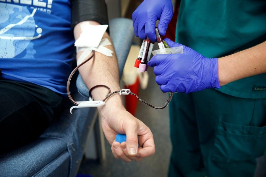 Mobile supervisor and phlebotomist Greg Calvert draws blood from Matt Burnside of Dallas to start the process of apheresis. 