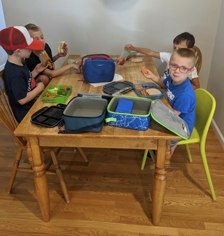 Members of a learning pod sit down to eat lunch together. 