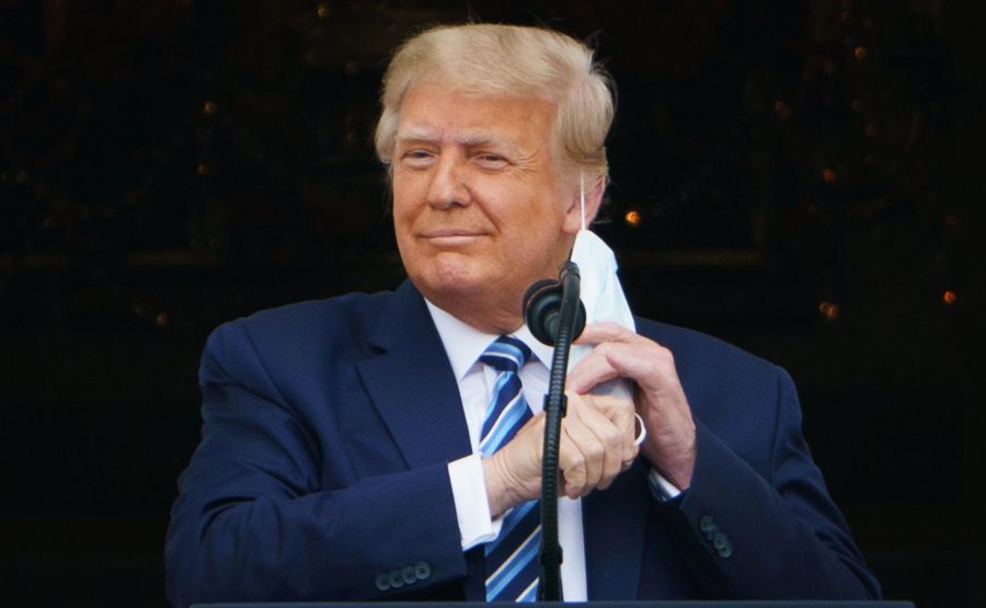 U.S. President Donald Trump takes his mask off before speaking at a rally from the South Portico of the White House in Washington, D.C. on Oct. 10, 2020.