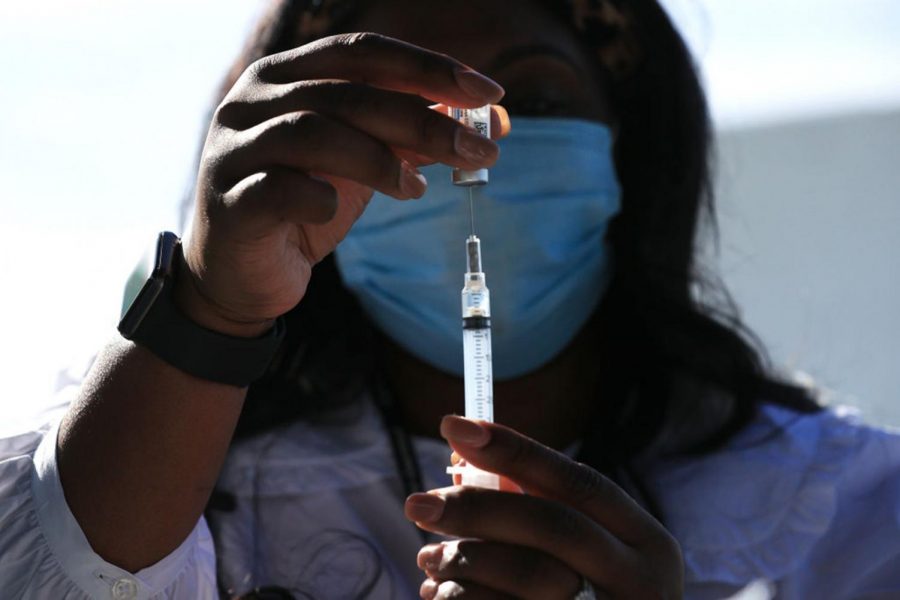 DC Health nurse manager Ashley Hennigan fills a syringe with a dose of the Johnson and Johnson coronavirus vaccine during a walk-up clinic at the John F. Kennedy Center for the Performing Arts' outdoor Reach area on May 6, 2021, in Washington, D.C.