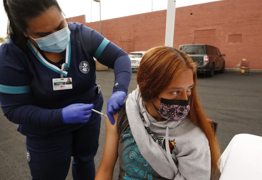 Jamilette Mota, 17, receives a Pfizer COVID-19 vaccination from student registered nurse Josselyn Solano at a walk-up mobile clinic in April 2021 in Los Angeles. (Al Seib/Los Angeles Times/TNS).