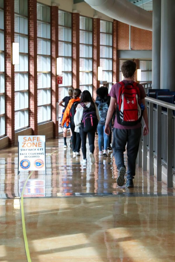 Students walk down the hallway during the COVID-19 pandemic after returning to school