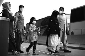 Refugees walk to board a bus at Dulles International Airport after being evacuated from Kabul following the Taliban takeover of Afghanistan on Tuesday, Aug. 31, 2021, in Dulles, Virginia. (Anna Moneymaker/Getty Images/TNS)