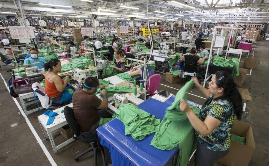 Garment workers sewing t-shirts on the warehouse floor at Los Angeles Apparel on August 4, 2017, in Los Angeles. 
