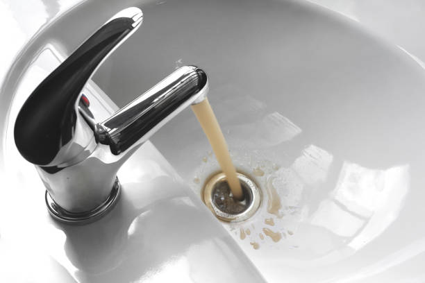 Water pouring from a faucet, an unappetizing brownish color.