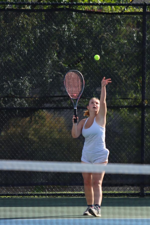 Sophia Martin serves a tennis ball during a senior night match. 