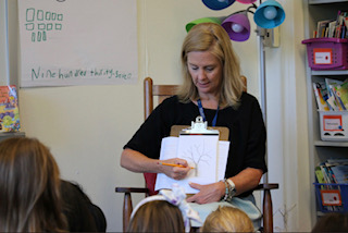 Mrs Scott drawing a tree for an elementary class.