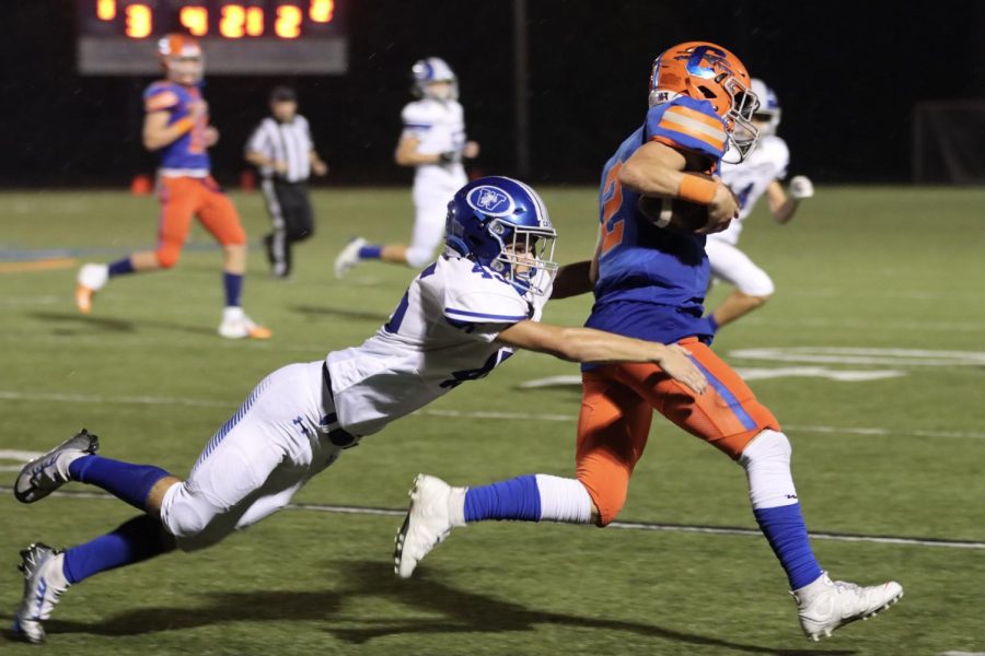 CHS football player runs a ball away from an opposing player. 